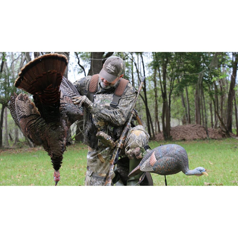 man holding dead turkey hunting with decoy